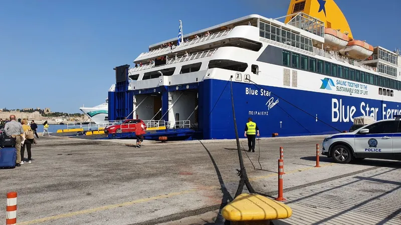 Passengers with wheeled luggage walking across a quay towards the open stern ramp of a ferry