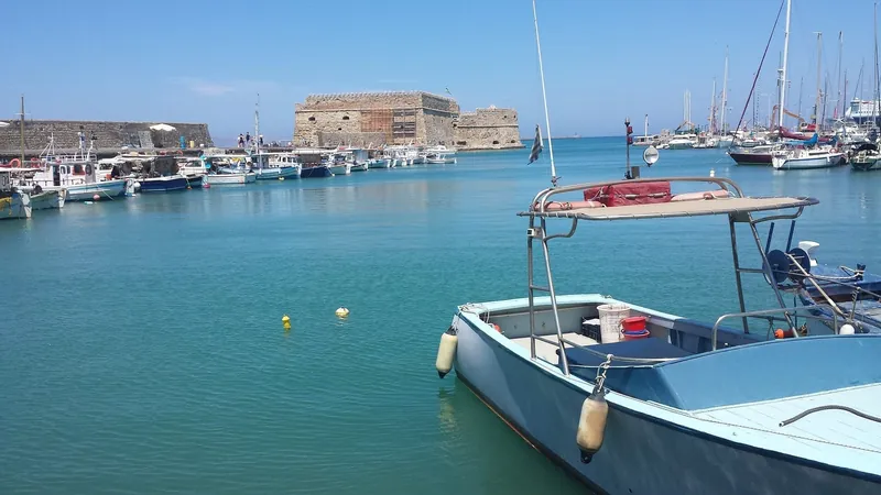 The old harbour in Heraklion with fishing boats and the Venetian fortress behind
