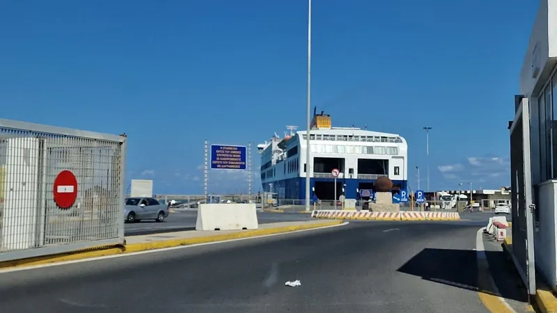 The road into a ferry port with a ferry loading at the quay ahead