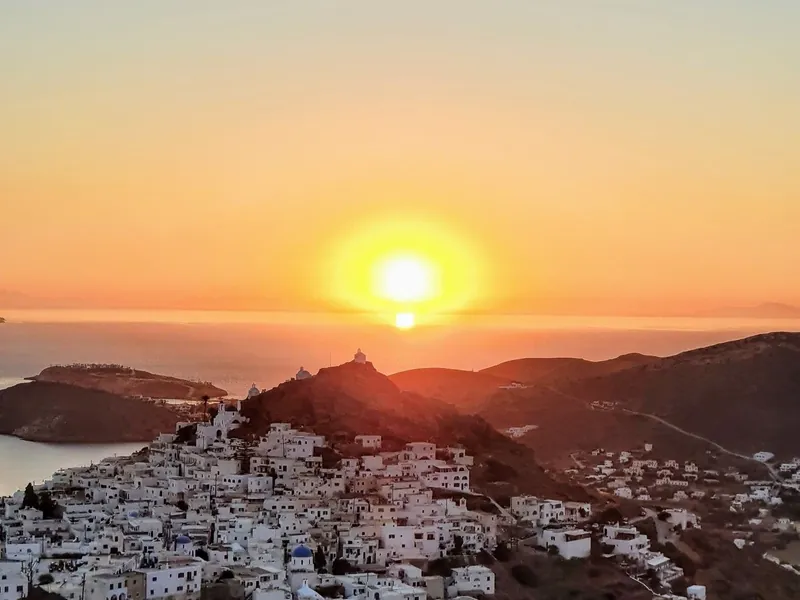 Sunset over the white houses of Ios Chora and the sea beyond