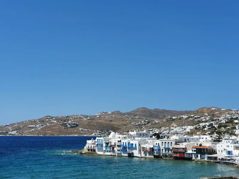The waterfront houses of Little Venice in Mykonos Town beside deep blue water