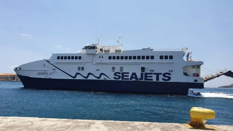 A white Seajets high-speed ferry arriving at the harbour on Syros